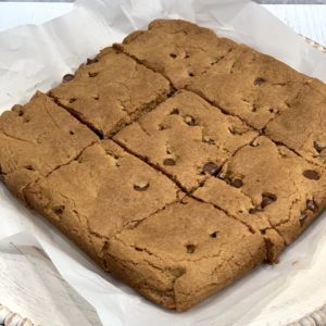 finished gluten free blondie recipe cut into 9 squares on white parchment paper