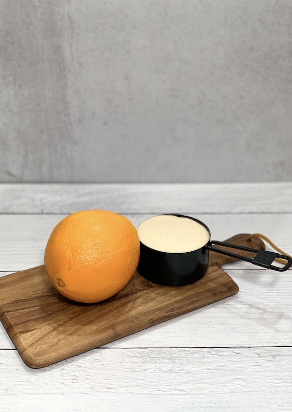 orange and sugar on a wooden cutting board